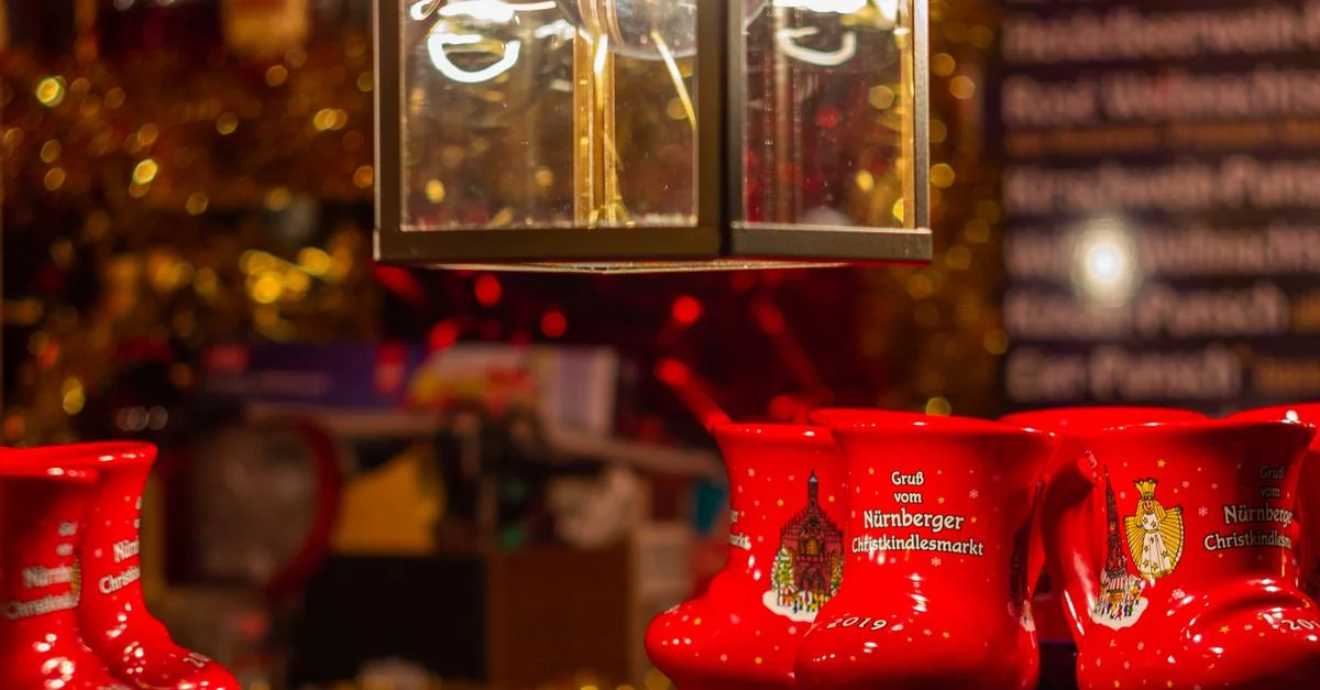 Mugs rouges festifs en exposition lors de la nuit au marché de Noël de Nuremberg.