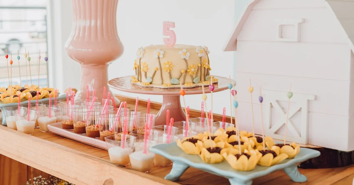Une ambiance d'anniversaire colorée avec un gâteau et des friandises variées sur une table décorative à l'intérieur.