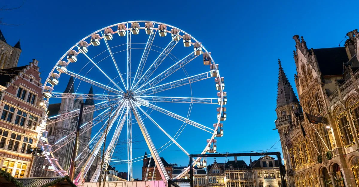 Explorez un marché de Noël animé sous une grande roue scintillante sur la place historique de Gand.