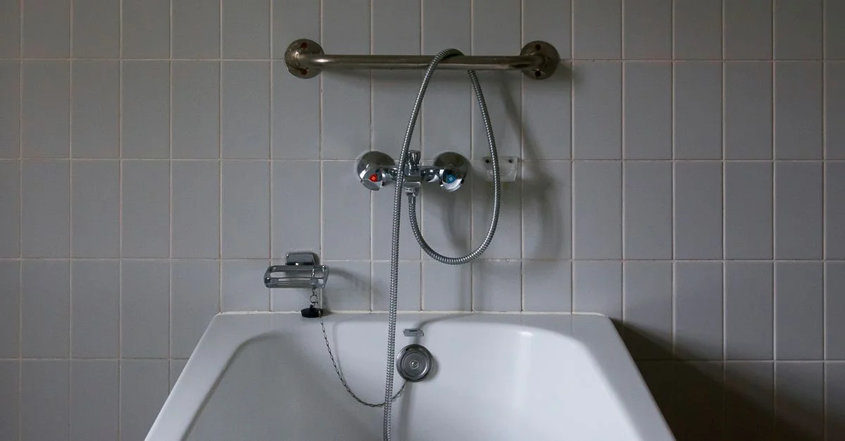 Gros plan d'une salle de bain minimaliste avec une baignoire moderne et un robinet en chrome contre des murs carrelés.